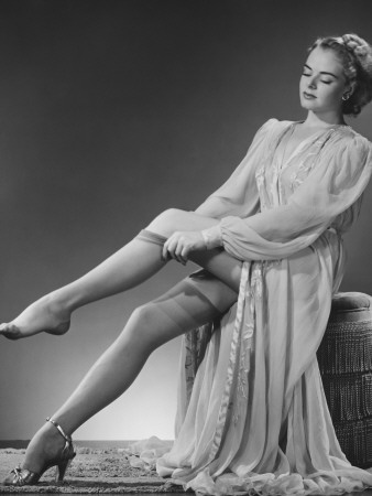 Young Woman Putting on Stockings in Studio